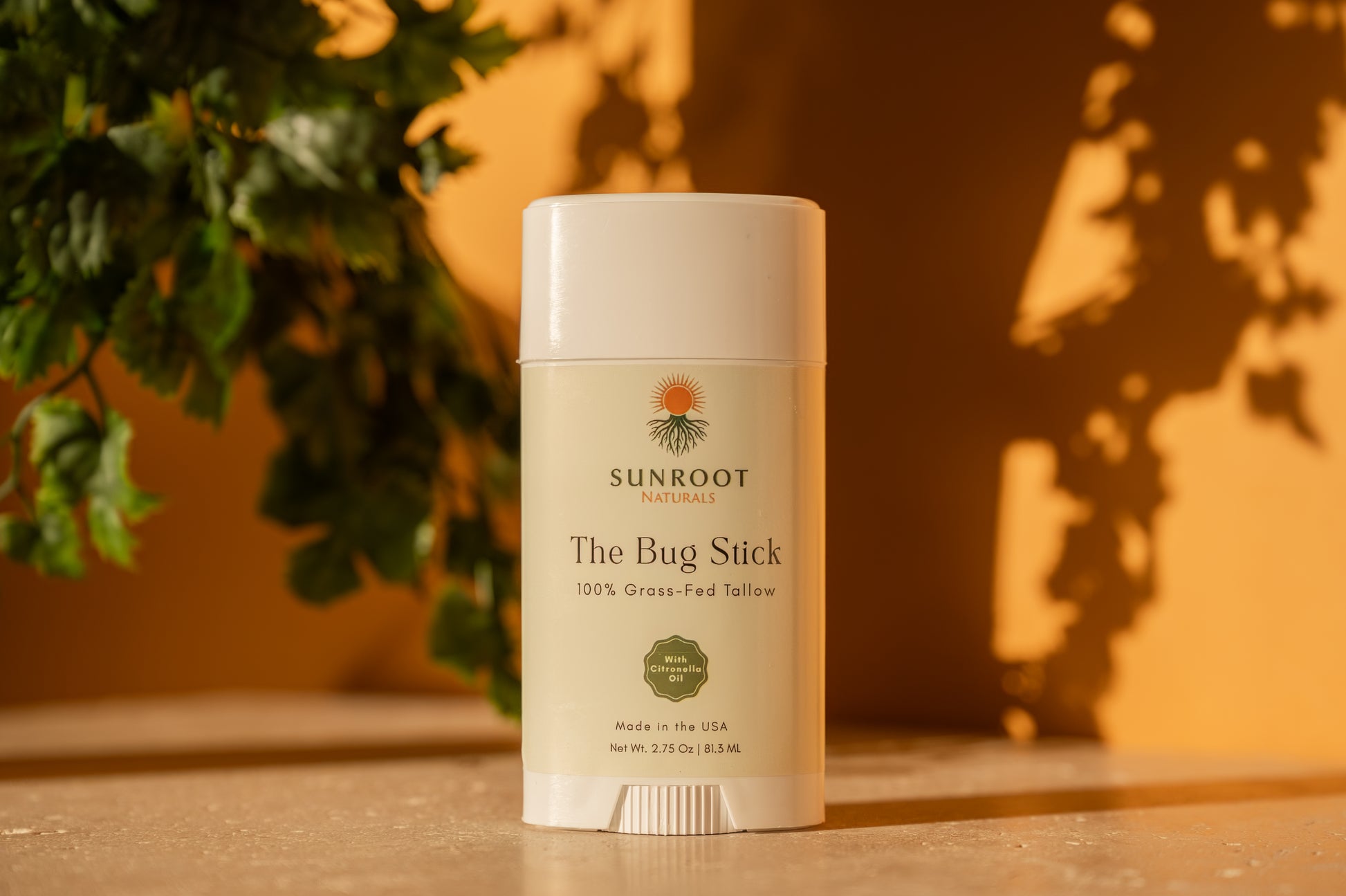 Sunroot The Bug Stick insect repellent displayed in a warm indoor lifestyle setting with botanical accents.