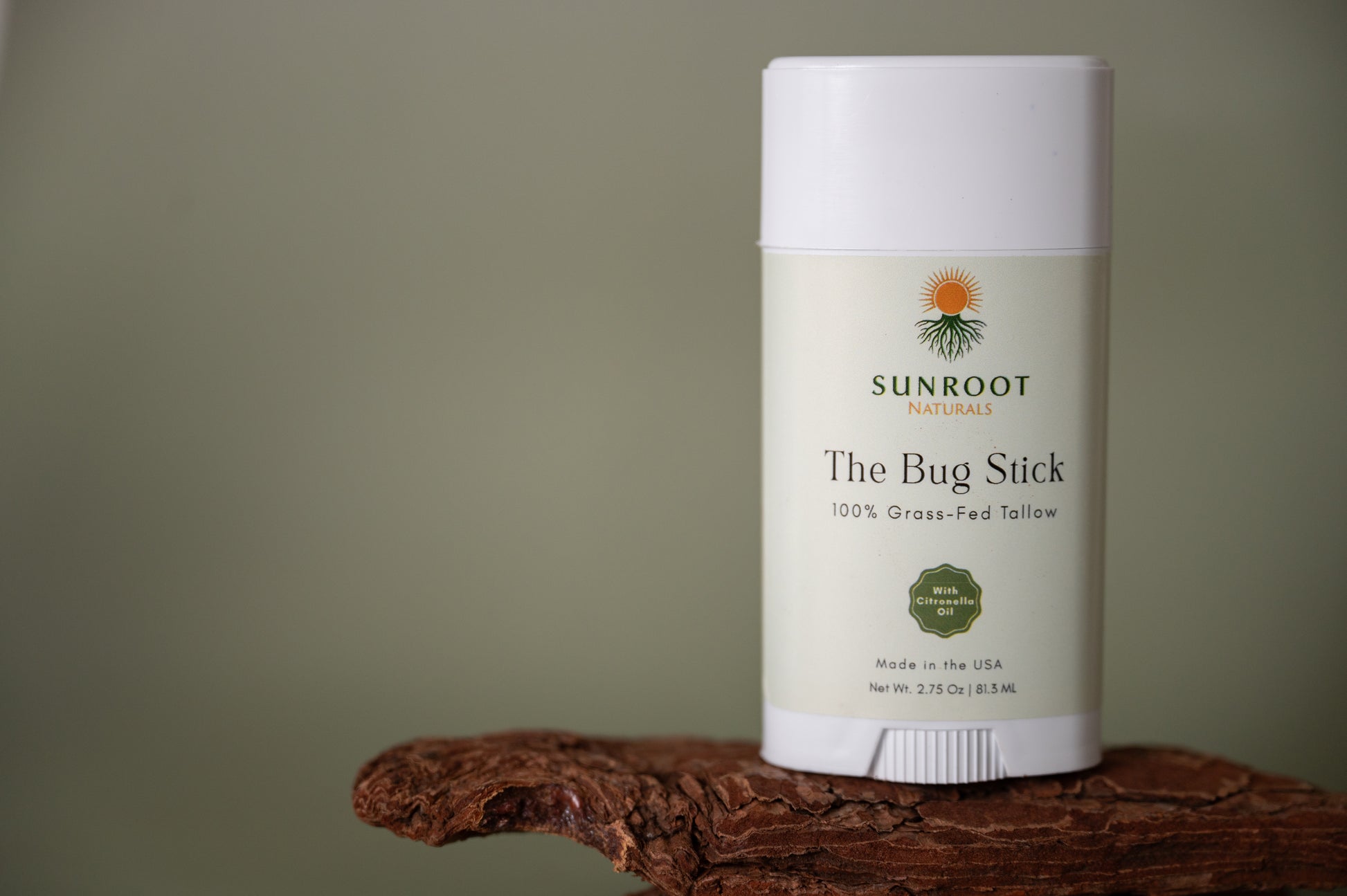 Sunroot The Bug Stick insect repellent displayed on natural wood surface.